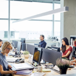 People working on computers in a modern office, representing a bustling IT company environment.