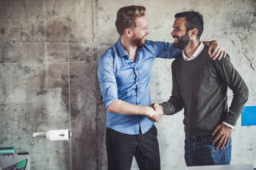 Two businessmen shake hands in agreement, symbolizing partnership in licensing within the IFZA Free Zone.